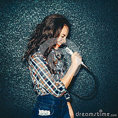 Crazy girl holding microphone and smiling. Attractive Beautiful Stock Photo