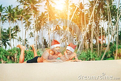 Crazy happy father and son lie on tropical sand beach in Sants h Stock Photo