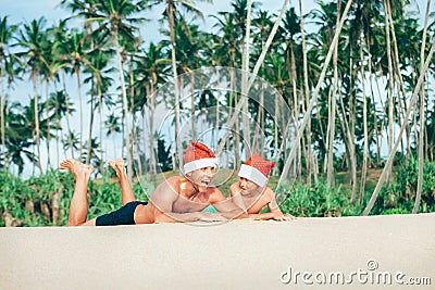 Crazy happy father and son lie on tropical sand beach in Sants h Stock Photo