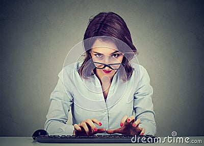 Crazy looking nerdy young woman typing on the keyboard wondering what to reply Stock Photo