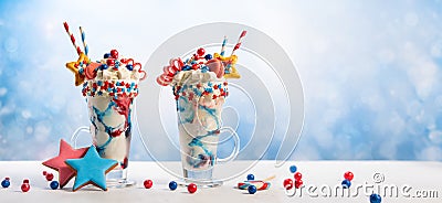 Crazy milk shake with ice cream,whipped cream, marshmallow,cookies and colored candy in glass. Sweet dessert for Fourth of July. Stock Photo