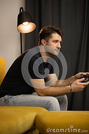 Crazy obsessed with games guy plays video game holding console gamepad in hands Stock Photo