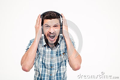 Crazy screaming bearded man listening to music using headphones Stock Photo