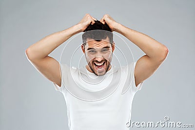 Crazy shouting man in t-shirt over gray background Stock Photo