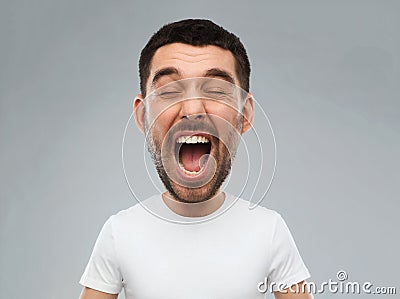 Crazy shouting man in t-shirt over gray background Stock Photo