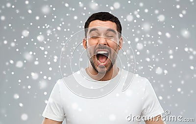 Crazy shouting man in t-shirt over snow background Stock Photo