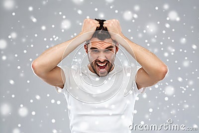 Crazy shouting man in t-shirt over snow background Stock Photo