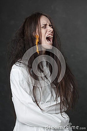 Crazy woman screaming in a straitjacket. Stock Photo