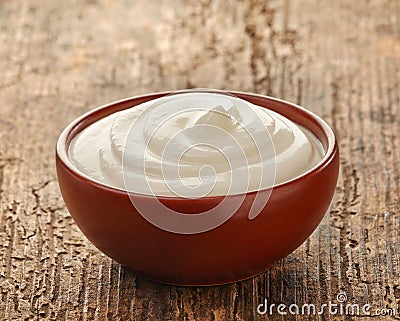 Cream in a brown ceramic bowl Stock Photo