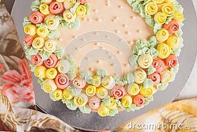 Cream cake decorated with small yellow and pink roses Stock Photo
