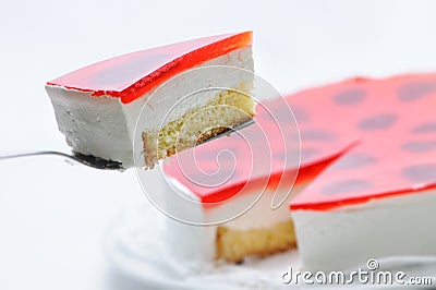 Cream cake on metal spoon, tart on white plate, cake with red gelatin, patisserie, photography for shop, birthday cake Stock Photo