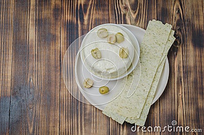 Cream cheese with olives and long chips in a bowl on a wooden background. Top view and copyspace. Food for snacks Stock Photo