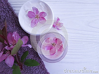 Cream cosmetic relaxation spa pink flowers organic on white wooden towel Stock Photo