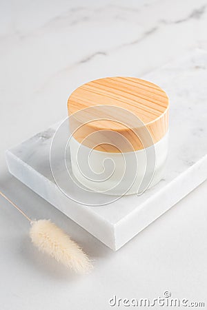 Cream jar on marble tray. Cosmetic skincare product blank frosted glass package. White unbranded lotion, balm, cream Stock Photo