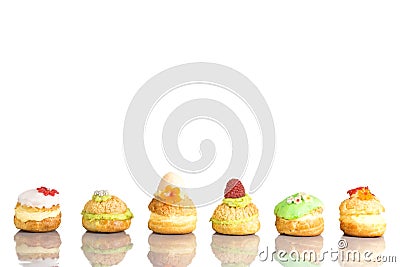 Cream puff cakes or profiterole filled with whipped cream with fruit and decoration in line Stock Photo