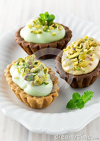 Cream tarts with pistachio and mint Stock Photo