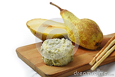 creamy blue stilton cheese, pears and cracker sticks on a cutting board, corner background fades to white, copy space Stock Photo