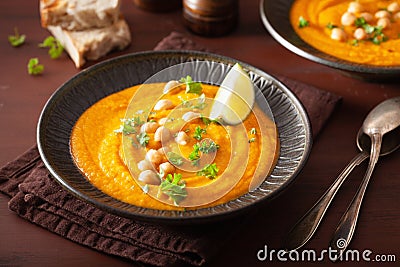 Creamy carrot chickpea soup on dark rustic background Stock Photo