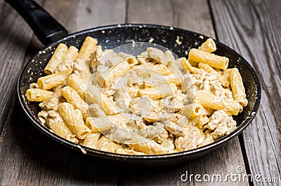 Creamy pasta with chicken and mozzarella cheese in pan Stock Photo