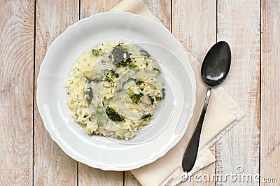Creamy risotto with broccoli on the cloth and wooden background Stock Photo