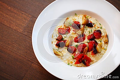 Creamy risotto with roasted cherry tomatoes and garlic Stock Photo
