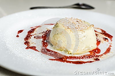 Creamy vanilla panna cotta in raspberry sauce on the white plate Stock Photo