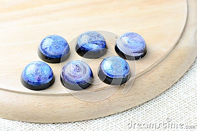 Create galaxy drink coasters using resin, glitter and pigment powders, handmade items. Suitable for keychains, necklace and Stock Photo