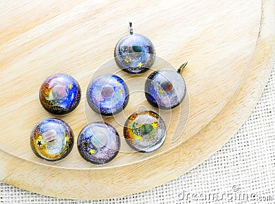 Create galaxy drink coasters using resin, glitter and pigment powders, handmade items. Suitable for keychains Stock Photo