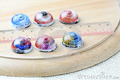 Create galaxy drink coasters using resin, glitter and pigment powders, handmade items. Suitable for keychains, necklace and Stock Photo