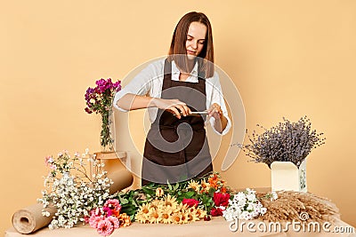 Creating content for working blog. Beautiful woman florist photographing a floral arrangements working with orders in floral Stock Photo