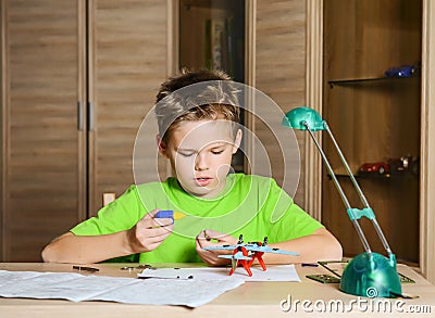 Creating the model plane. Happy boy making aircraft model. Hobby concept. Stock Photo