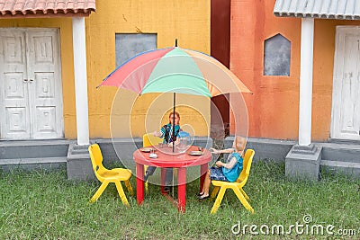 A creation Inspired by Gulliver`s Travels by Jonathan Swift.Funny picture of a Lilliput toys is sitting at a coffee table in yard Stock Photo