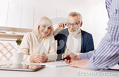 Creative agent showing house layout to aged couple of clients Stock Photo