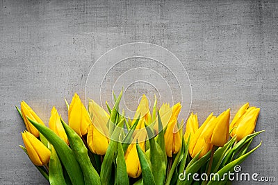 Creative arrangement of yellow tulips on gray rustic background for March 8, International Womens Day, Birthday , Valentines Day Stock Photo