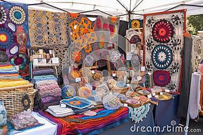 creative and artistic display of handmade crafts, including crocheted blankets, embroidered pillows, and knitted scarves Stock Photo