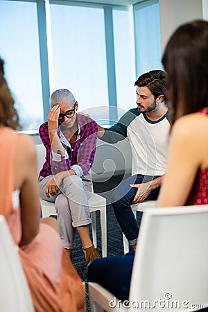 Creative business team consoling upset colleague Stock Photo