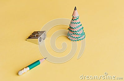 Creative christmas tree. Pencil for shavings, pencil and sharpener on a yellow background. Christmas concept in office Stock Photo