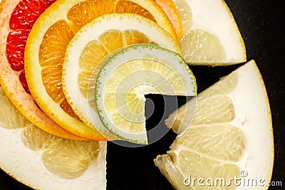 Creative citrus fruits slice on a black background, abstract. lemon, orange, lime, grapefruit, sweetie, pomelo Stock Photo