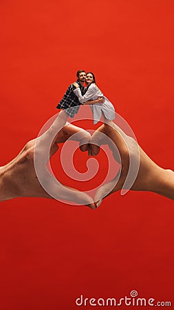 Creative collage with hands. Beautiful young couple, man and woman hugging over heart hand symbol, showing love and Stock Photo