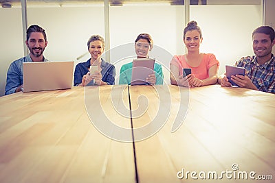 Creative colleagues with laptop and digital tablet smiling at camera Stock Photo