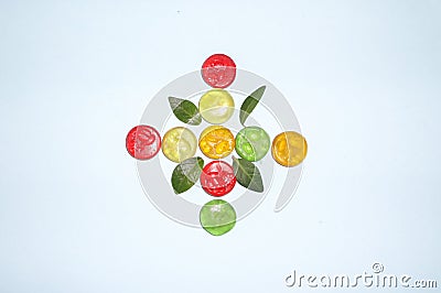 Creative colorful concept made of candy and leaves isolated on blue background .Fruit comcept Stock Photo