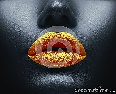 Creative colorful makeup. Bodyart, lipgloss on sexy lips, girls mouth. Golden lips on black skin Stock Photo