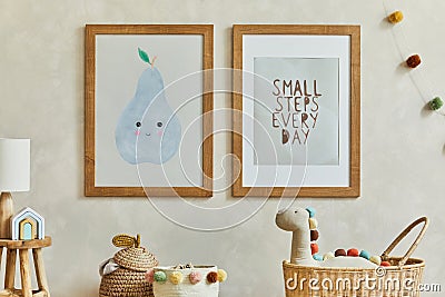 Creative composition of cozy scandinavian child`s room interior with two mock up poster frames, rattan basket, lamp, plush. Stock Photo