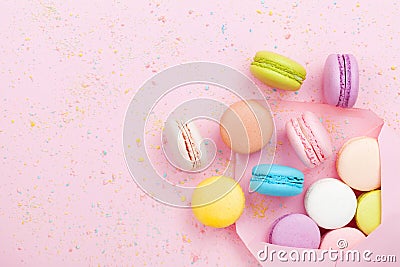 Creative composition with envelope and cake macaron or macaroon on pink pastel background top view. Flat lay. Stock Photo