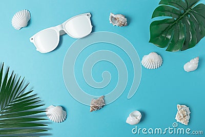 Creative composition with seashells, white sunglasses and palm leaves on pastel blue background. Summer minimal concept Stock Photo