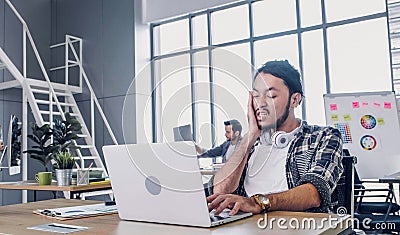 Creative designer slap face when sleepy while working hard with laptop at modern office.workplace lifesyle concept Stock Photo