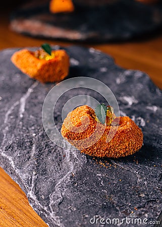 Creative Fine Dinning: Fish with orange colour glaze topping with ikura served on stone plate Stock Photo