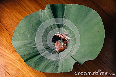 Creative Fine Dinning: Tuna with yuzu-miso topping with black caviar and avocado served in lotus leaf Stock Photo