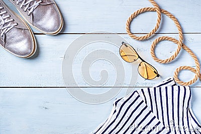 Creative flat lay concept of summer travel vacations. Top view of shiny sneakers, sunglasses and rope on pastel blue background wi Stock Photo