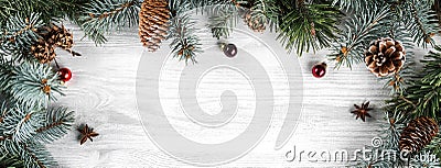 Creative frame made of Christmas fir branches on white wooden background with red decoration Stock Photo